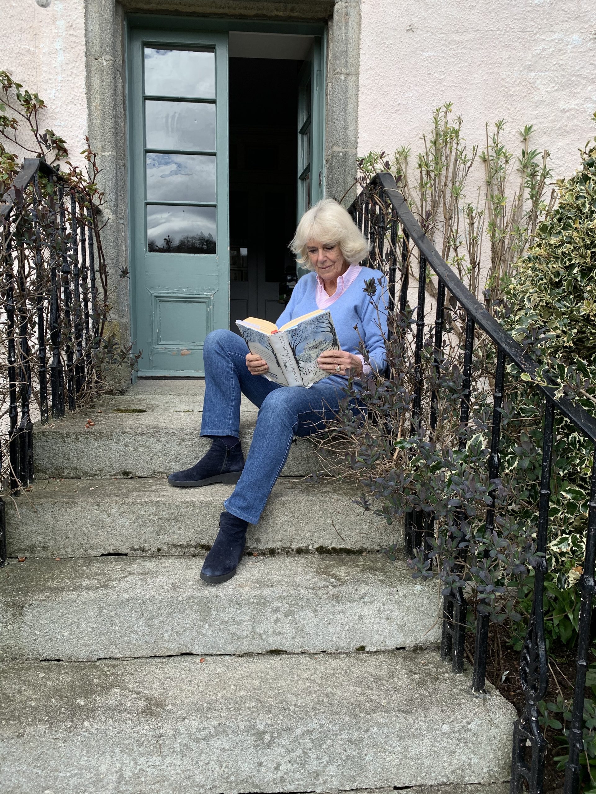 The Duchess of Cornwall reads 'All Change' - part of The Cazalet Chronicles - on a step at Birkhall (Clarence House)