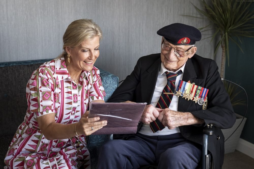 The Duchess of Edinburgh, patron of the Java Far East Prisoner of War Club 1942, views photographs with 105-year-old Royal Marines veteran James 'Jim' Wren, at the Sarum Manor Care Home in Salisbury, Wiltshire, ahead of the 80th anniversary of VJ Day. Picture date: Tuesday August 12, 2025.