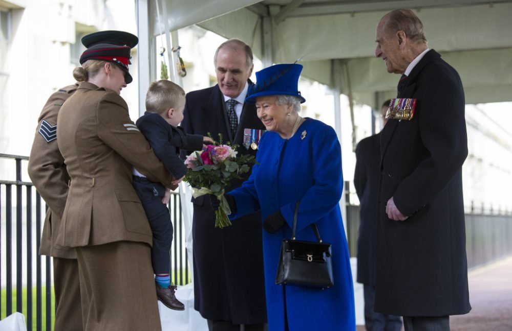 The Queen receives flowers as she arrives for the memorial dedication earlier today. Toddler Alfie didn't seem to want to meet the Monarch (MoD)