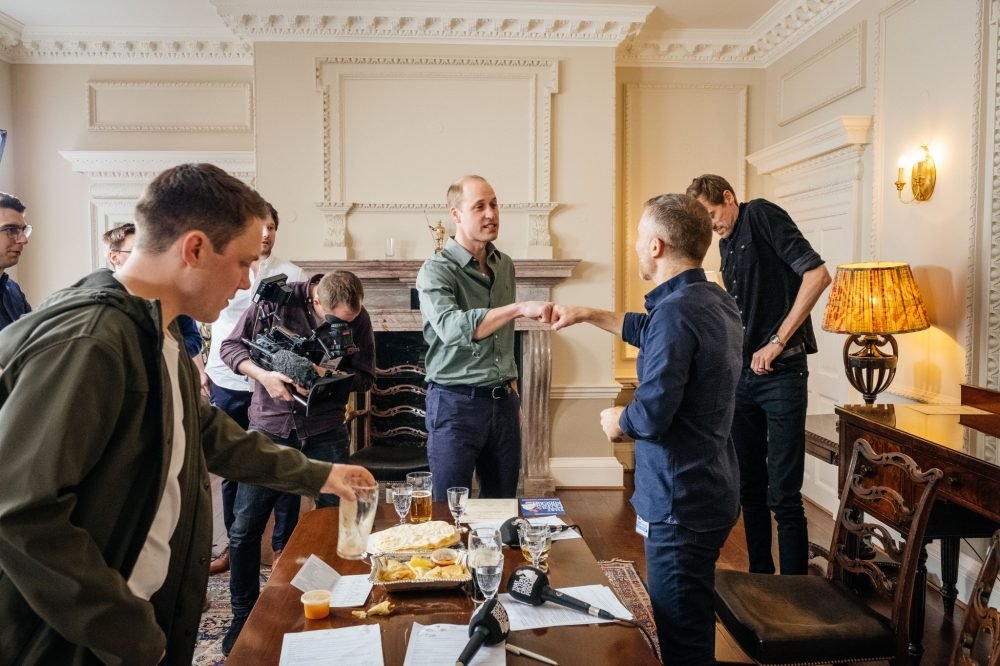 Prince William greets team members at Kensington Palace, where he took part in an episode of Peter Crouch's podcast