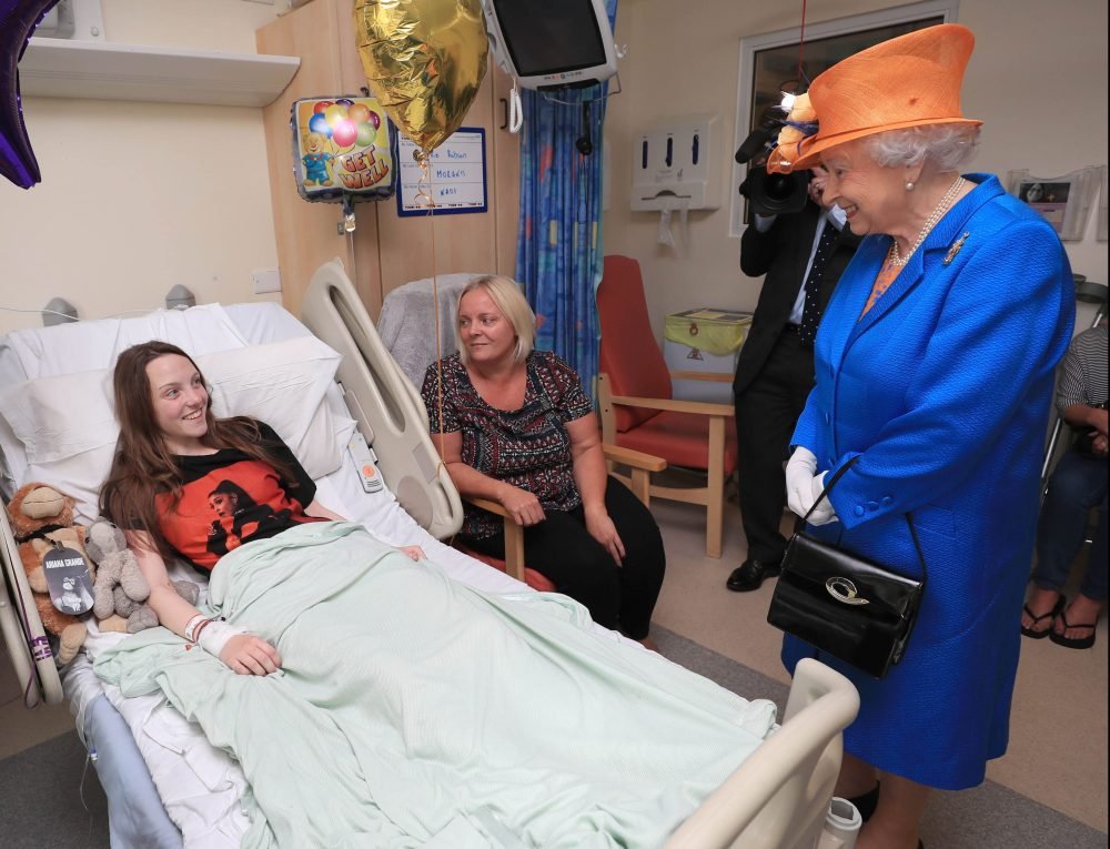 The Queen speaks to Millie Robson, 15, during a visit to the Royal Manchester Children's Hospital to meet victims of the terror attack earlier this week. Picture by  i-Images / Pool