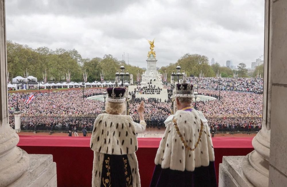 Charles and Camilla waving from the balcony of Buckingham Palace after the Coronation at Westminster Abbey. (Royal Family).